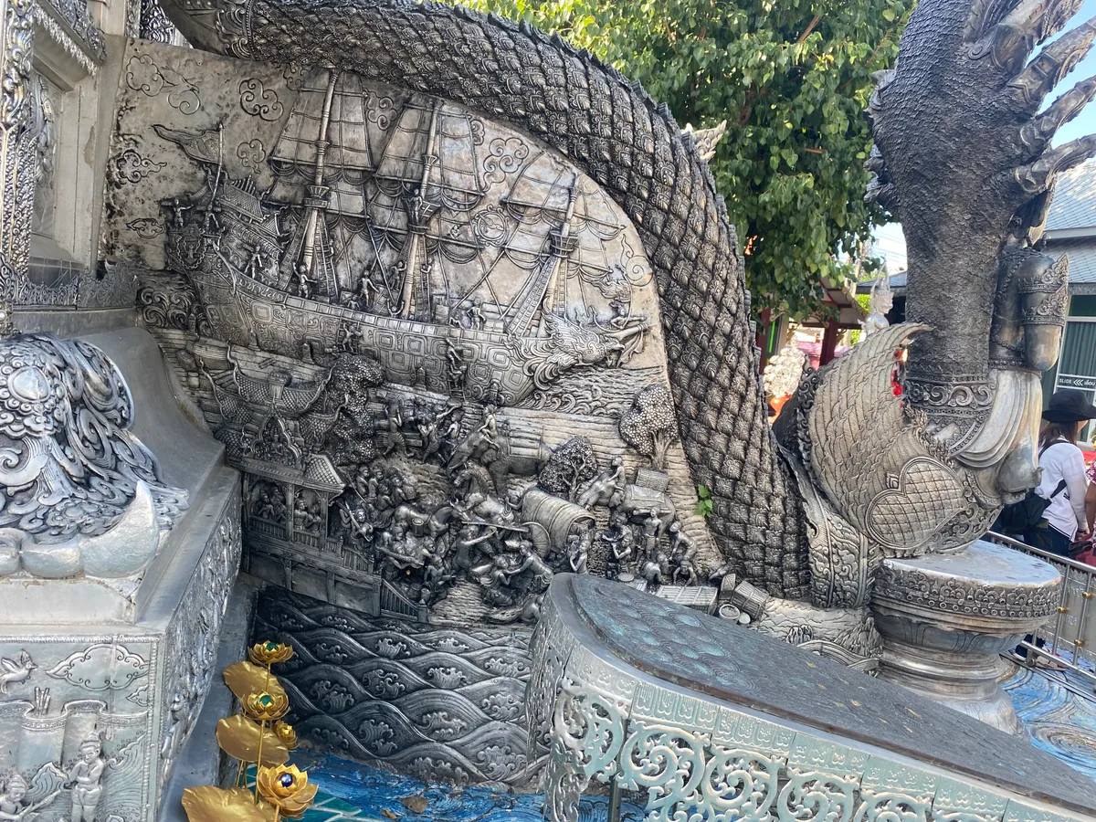 งานสลักดุนภาพเรือสำเภาโบราณ หนึ่งในลวดลายเล่าเรื่องบนผนังอุโบสถเงิน